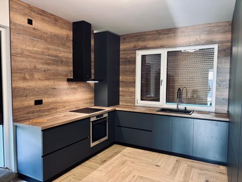 Bucătărie antracit pe colț cu blat și placare de perete cu decor de lemn