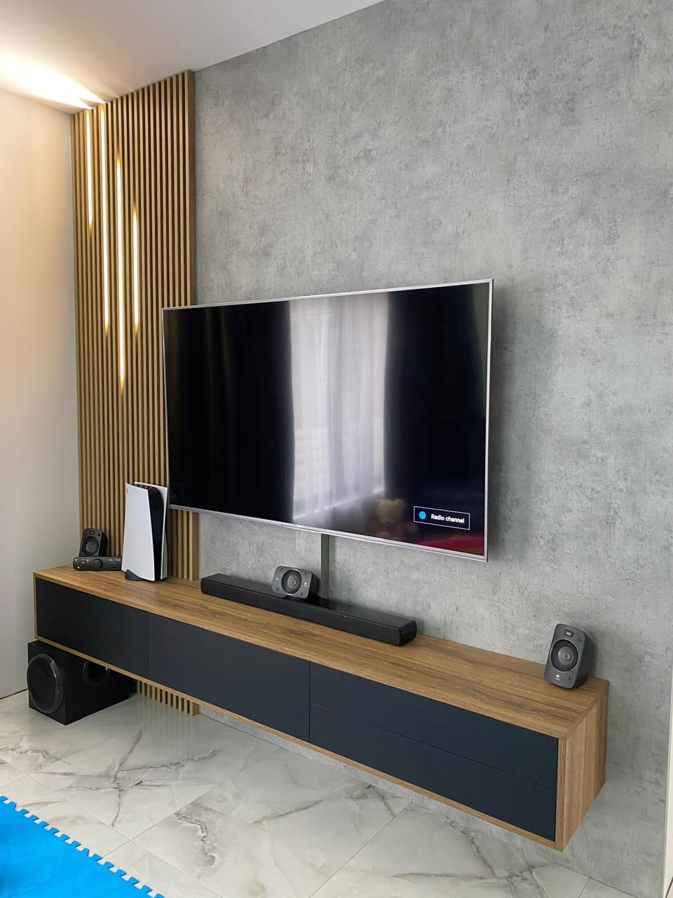 Perete TV cu comodă antracit, decor de lemn și riflaje verticale
